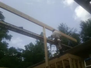 Carpenter setting a ridge beam over a new addition frame — Ice Dam Removal by Roofing Brothers in Woodbine